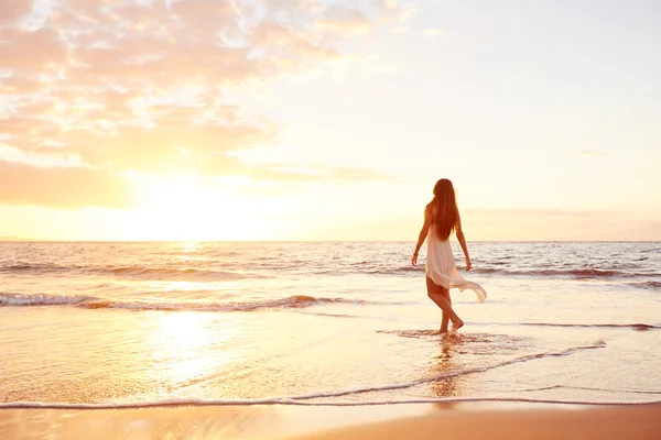 Ευτυχισμένη γυναίκα ανέμελα στην παραλία στο ηλιοβασίλεμα — Φωτογραφία Αρχείου