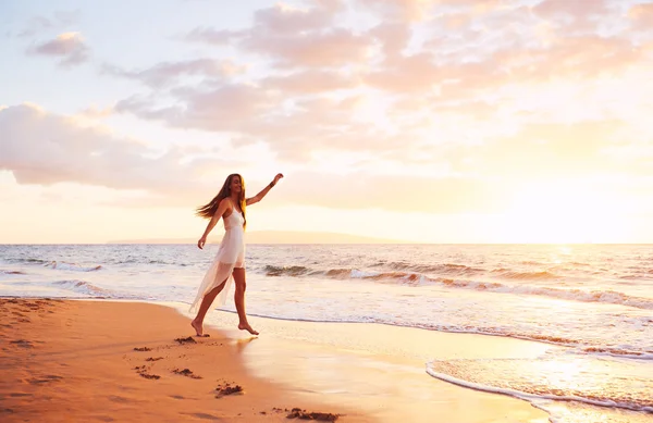 Felice donna spensierata che balla sulla spiaggia al tramonto — Foto Stock