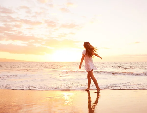 Glückliche unbeschwerte Frau am Strand bei Sonnenuntergang — Stockfoto