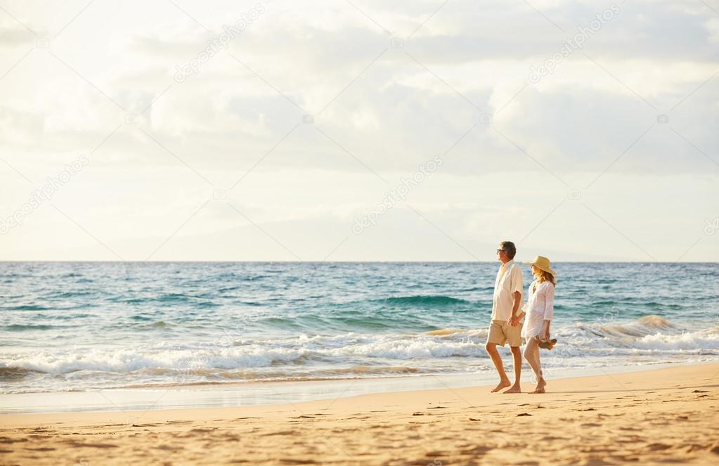 Mature Couple Walking on the Beach at Sunset