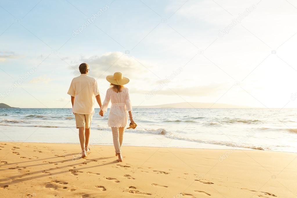 Mature Couple Walking on the Beach at Sunset