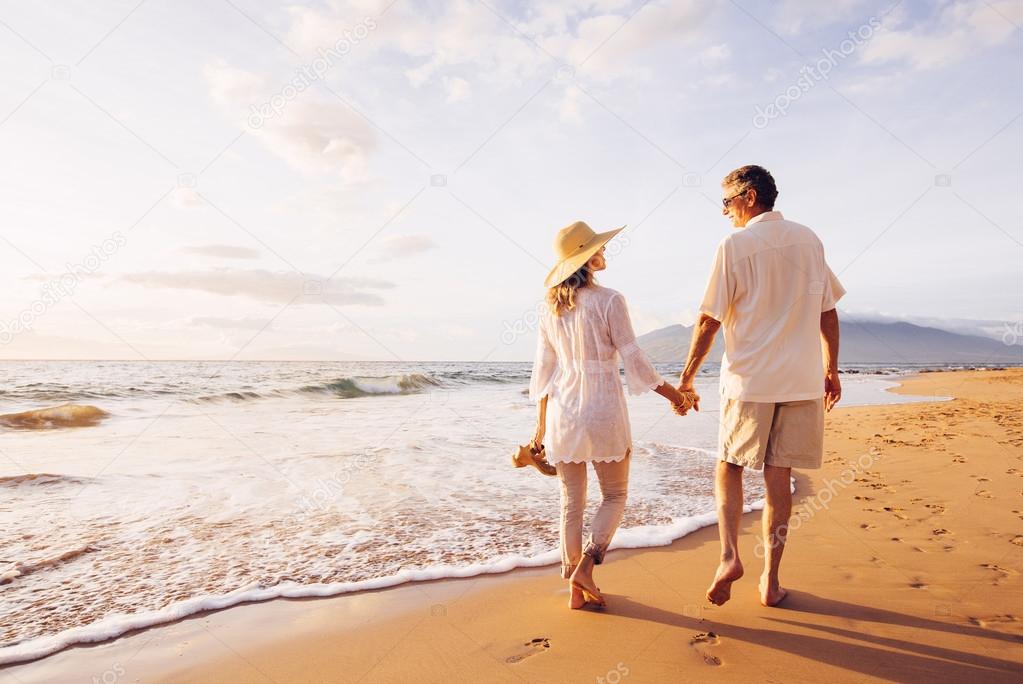 Mature Couple Walking on the Beach at Sunset