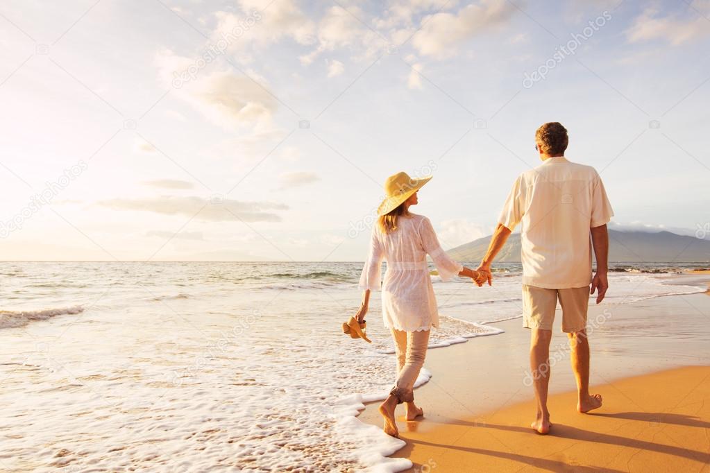 Mature Couple Walking on the Beach at Sunset