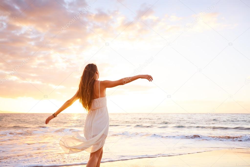 Happy Carefree Woman Dancing on the Beach at Sunset