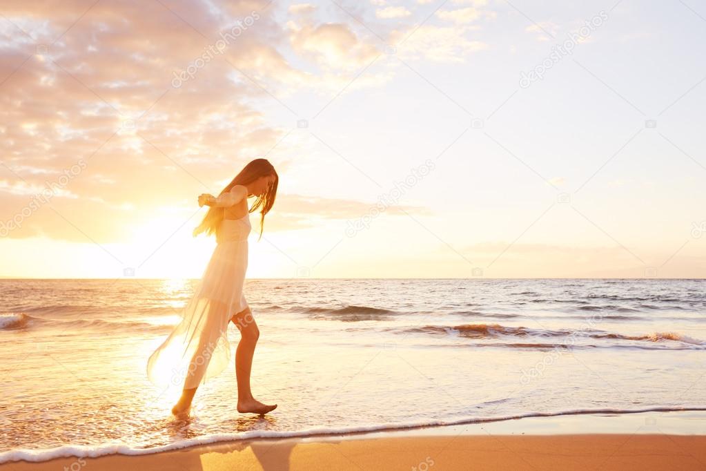 Happy Carefree Woman Dancing on the Beach at Sunset