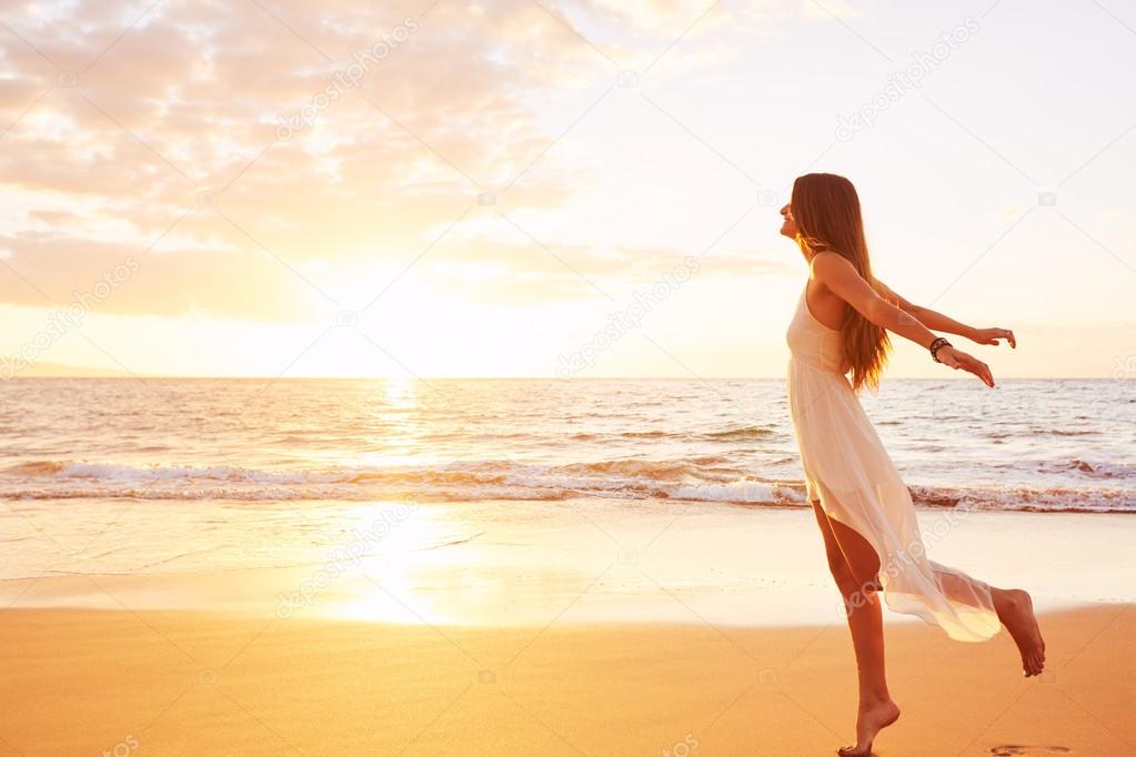 Happy Carefree Woman Dancing on the Beach at Sunset