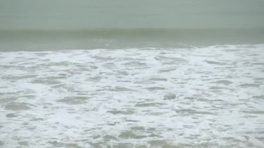 Şiddetli fırtına altında okyanus manzarası. Güçlü rüzgar havası ve kumsala doğru şiddetli dalgalar..