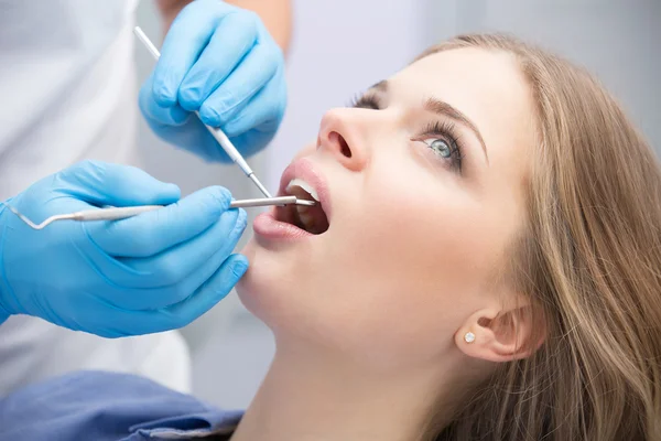 Dentista che esamina un paziente denti nel dentista. — Foto Stock