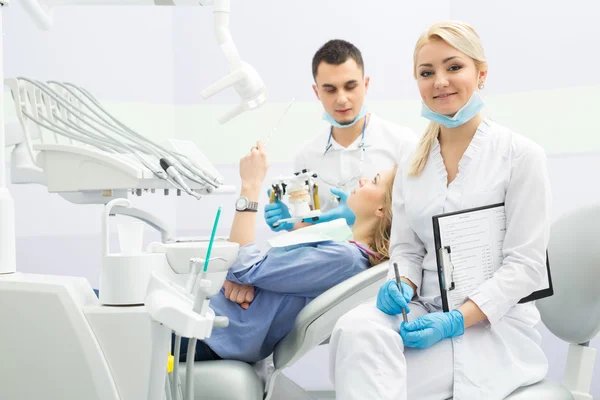 Moderní zubní klinika, mladý zubař pracující — Stock fotografie
