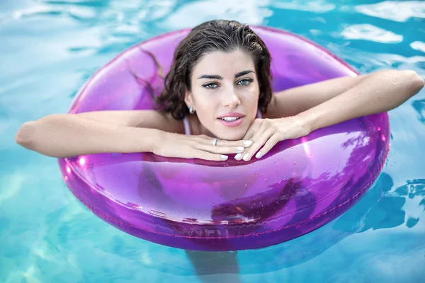 Model in rubber ring in swimming pool — Stock Photo, Image