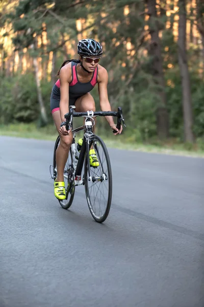 Athletic girl rides a bike — Stock Photo, Image