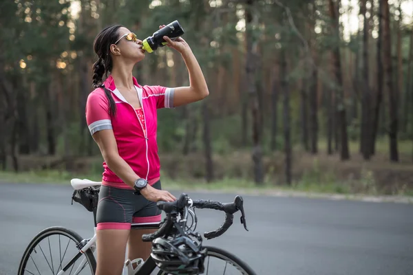 Dívka s cyklistických drinky z baňky — Stock fotografie