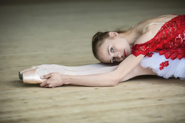 Очаровательная молодая танцовщица, растянувшись, наклонилась, глядя на Лицензионные Стоковые Изображения