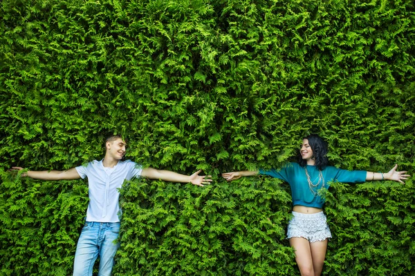 Jeune couple ferme les yeux sur le feuillage vert vif — Photo