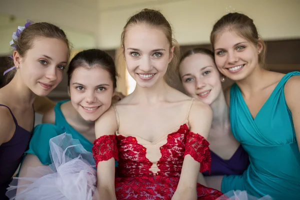 Cinco jóvenes bailarinas sentadas en el suelo y mirando a la ca — Foto de Stock