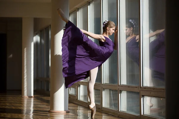 Pełen wdzięku baleriny dancing w strój purpurowy nogę podniósł wysoko, st — Zdjęcie stockowe