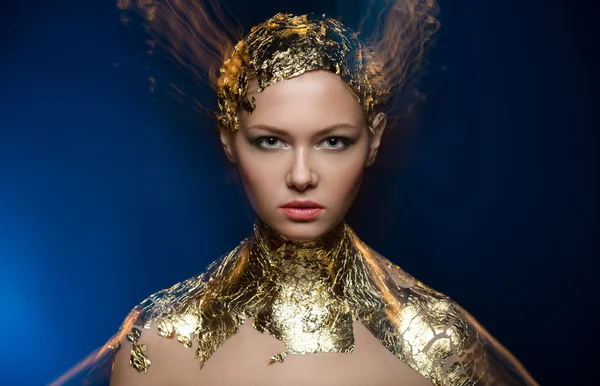 Close-up πορτρέτο μοντέλο κορίτσι σε ένα κομψό χρυσό φύλλο αλουμινίου. Θολή Μαρ — Φωτογραφία Αρχείου