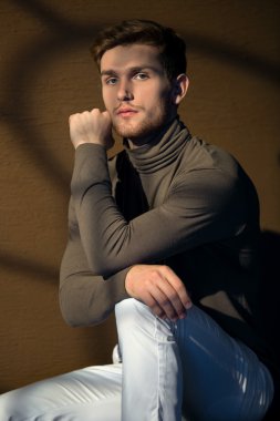 Looki penceresinden ışık ışınları içinde oturan yakışıklı adam