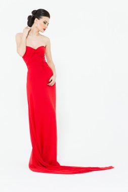 Seksi esmer bir sinsi parlak kırmızı elbiseli akşam w izole