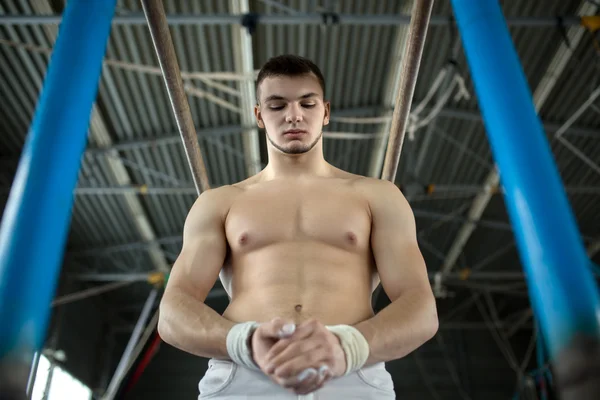 Atleet topless voorbereiding te geven gymnastische oefeningen op de une — Stockfoto