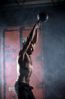 Güzel atlet kettlebell yapıyor salıncaklar. Profil resmi. Athl