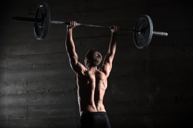 Arkadan bir yakışıklı sporcu portresi. B atlet yükseltir