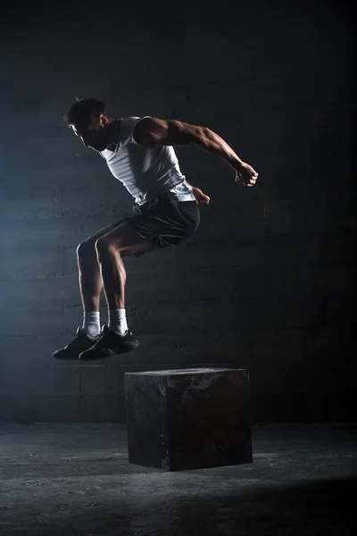 Atleet gaf oefening. Springen op de doos. Fase touchdown. — Stockfoto