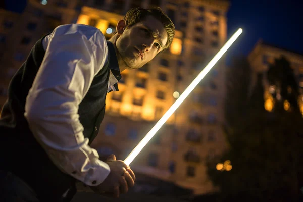 Handsome guy holding a lightsaber Jedi — Stock Photo, Image