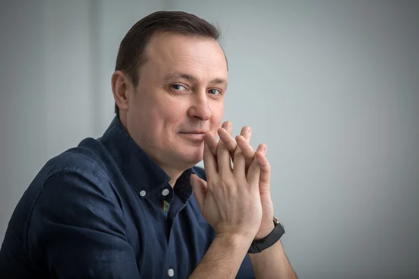 Man sitting with a slight smile — Stock Photo, Image