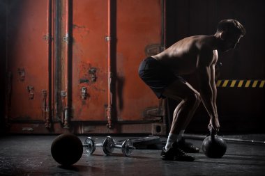 Güzel atlet kettlebell yapıyor salıncaklar
