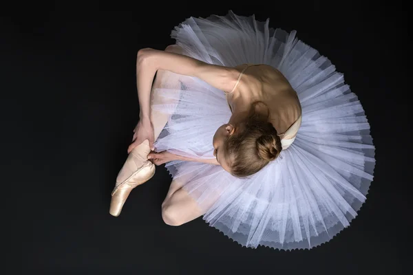 Giovane ballerina legare punta seduta sul pavimento — Foto Stock