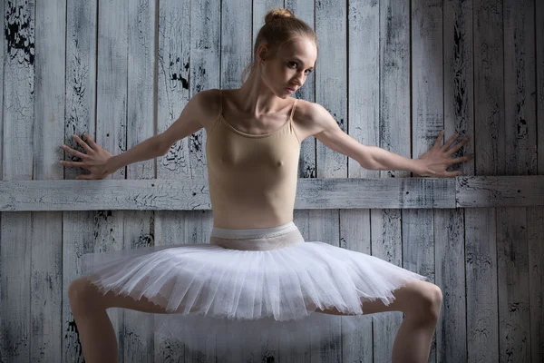 Ballerina står nära en trävägg — Stockfoto