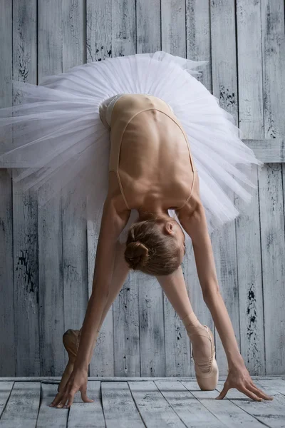 Ballerina klädd i vit tutu gör lean fram — Stockfoto