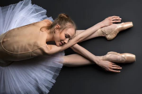 Graciösa ballerina sitter på golvet — Stockfoto