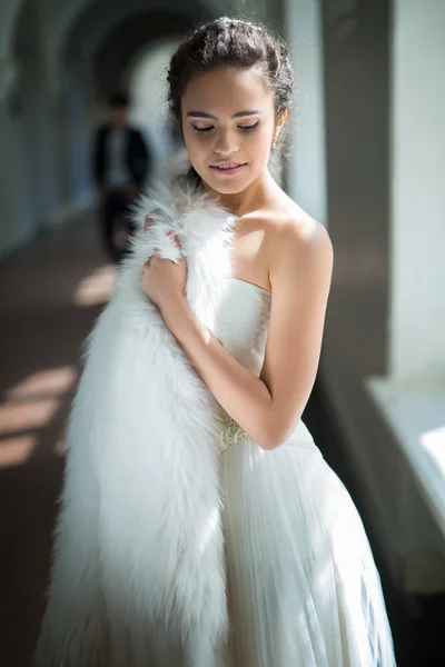 Delicate bride with curly hair standing near the window — Stock Photo, Image