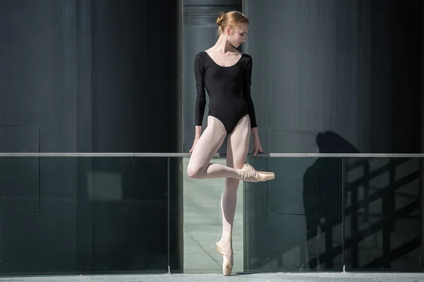 Giovane ballerina graziosa in costume da bagno nero su uno sfondo o — Foto Stock