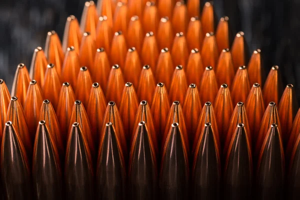 Macro shot of copper bullets that are in many rows to form a tri