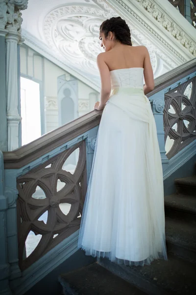 Elegante Braut im weißen Kleid auf der Treppe — Stockfoto