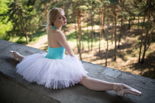 Gracieuze ballerina in witte tutu zittend op de splitsingen — Stockfoto