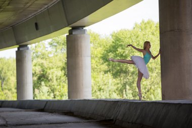 zarif balerin dans egzersizleri bir beton köprü yapıyor 