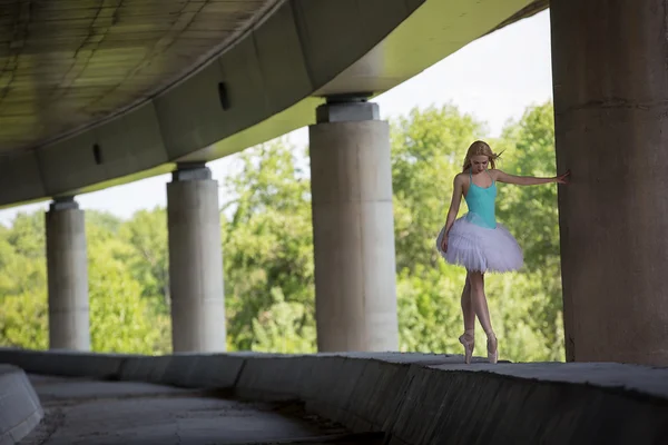 Bailarina elegante haciendo ejercicios de baile en un puente de hormigón —  Fotos de Stock