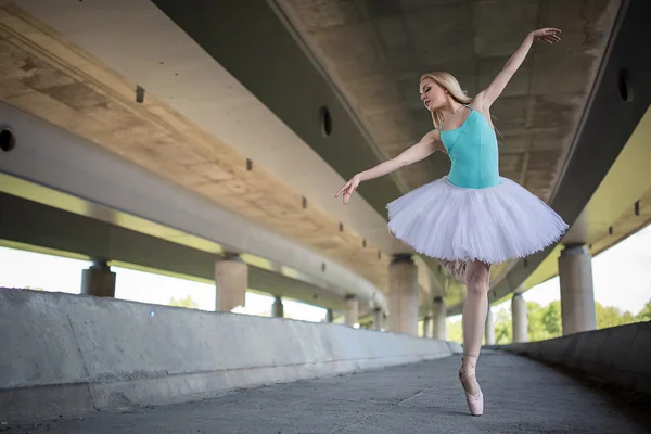 Χαριτωμένη μπαλαρίνα κάνει ασκήσεις χορού σε μια τσιμεντένια γέφυρα — Φωτογραφία Αρχείου