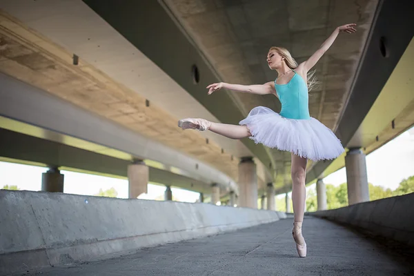 Ballerina graziosa che fa esercizi di danza su un ponte di cemento — Foto Stock