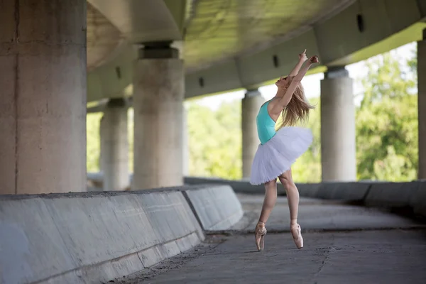 Gracieuze ballerina doen dans oefeningen op een betonnen brug — Stockfoto