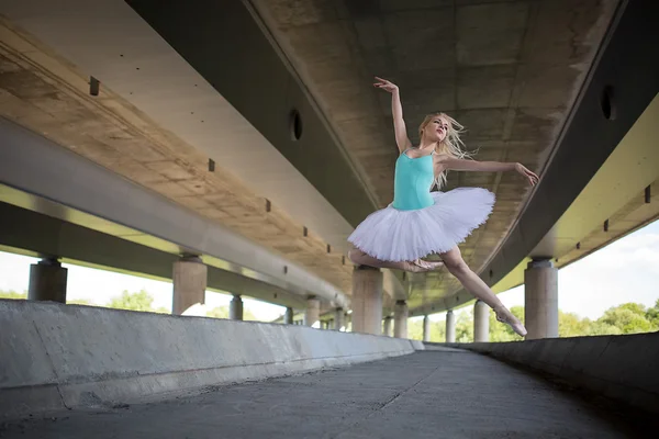 Ballerina graziosa che fa esercizi di danza su un ponte di cemento — Foto Stock