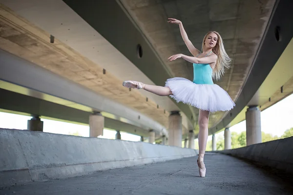 Χαριτωμένη μπαλαρίνα κάνει ασκήσεις χορού σε μια τσιμεντένια γέφυρα — Φωτογραφία Αρχείου