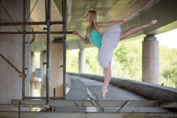 Gracieuze ballerina doen dans oefeningen op een betonnen brug — Stockfoto