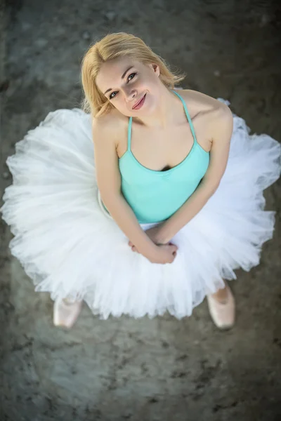 Ganska blond ballerina tittar upp på kameran. — Stockfoto
