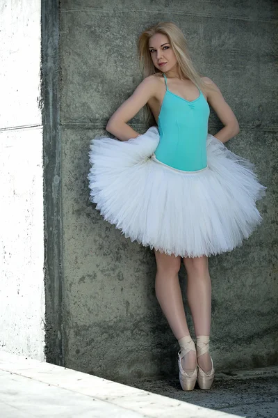Anmutige Tänzerin mit blonden Haaren vor grauem Hintergrund — Stockfoto