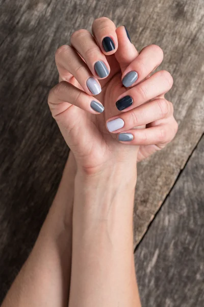 Belas mãos com a miniatura pintada em um nai de cor cinza — Fotografia de Stock